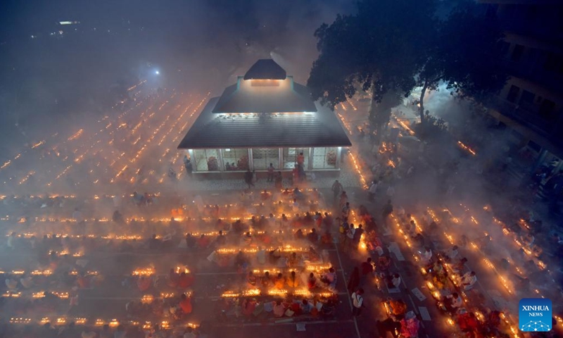 Devotees sit for prayer with burning incense and light oil lamps during the Rakher Upobash, a religious fasting festival, at a temple in Narayanganj, Bangladesh, on Nov. 14, 2023. (Photo: Xinhua)