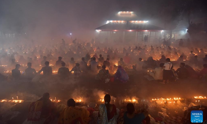 Devotees sit for prayer with burning incense and light oil lamps during the Rakher Upobash, a religious fasting festival, at a temple in Narayanganj, Bangladesh, on Nov. 14, 2023. (Photo: Xinhua)