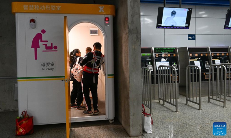 A couple change diaper for their baby at a mobile nursery within the Hongshuwan Station of Shenzhen Metro in Shenzhen, south China's Guangdong Province, Nov. 17, 2023. Shenzhen launched China's first guidelines for building a child-friendly city eight years ago. Since then the city has been rolling out a spate of measures spearheading the construction towards this aim. (Photo: Xinhua)