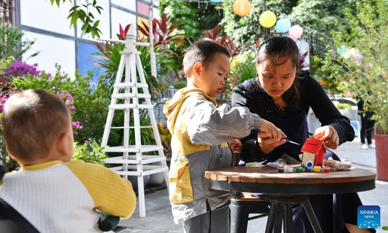 A mother does handwork with her child in Shangwei Village, a child-friendly arts village, in Longhua District of Shenzhen, south China's Guangdong Province, Nov. 19, 2023. Shenzhen launched China's first guidelines for building a child-friendly city eight years ago. Since then the city has been rolling out a spate of measures spearheading the construction towards this aim. (Photo: Xinhua)