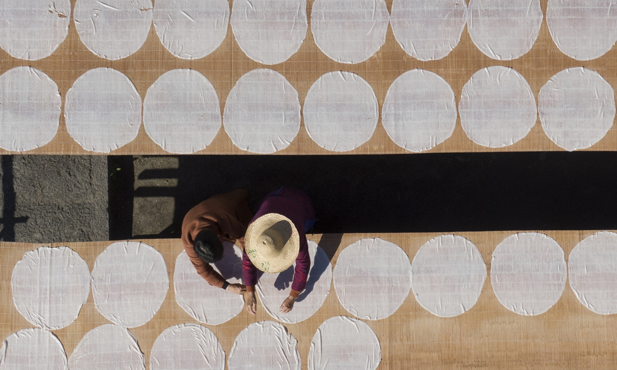 Villagers dry rice flour, a local specialty, under the sun at Xinguang village, East China's Zhejiang Province on November 21, 2023. Production of the specialty has become an efficient way for local villagers to increase their incomes. Photo: VCG