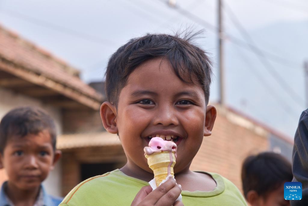 A boy enjoys an Aice ice cream in Mojokerto, East Java, Indonesia, Sept. 14, 2023. Living in the tropics, the Indonesian people swelter through the scorching weather. Aice, a famous ice cream brand in the country, cools them down and brings joy.(Photo: Xinhua)