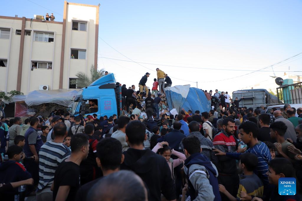 Palestinian people get drinking water from trucks loaded with food supplies in the southern Gaza Strip city of Khan Younis, on Nov. 21, 2023. The Palestinian death toll in the Gaza Strip has surpassed 14,000 since the current Israel-Hamas conflict broke out on Oct. 7, the Hamas-run government media office said Tuesday.(Photo: Xinhua)