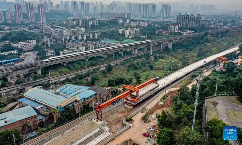 Workers conduct box girder erection work at the construction site of the Louwan grand bridge on the Chongqing-Kunming high-speed railway in southwest China's Chongqing Municipality, Nov. 21, 2023. The erection task of all box girders along a local section of a high-speed railway linking Chongqing, southwest China, and Kunming, capital of southwest China's Yunnan Province, was completed on Tuesday.(Photo: Xinhua)