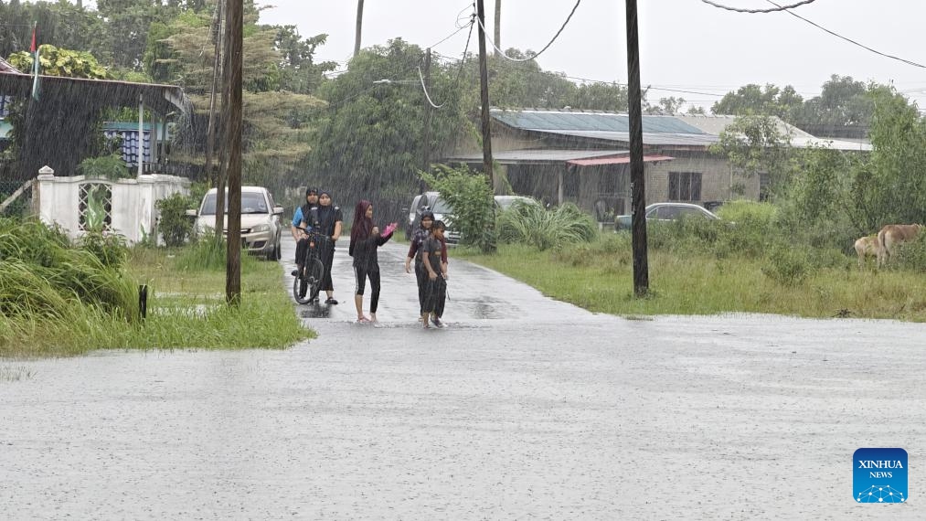 People stand in the rain in Terengganu state, Malaysia, Nov. 21, 2023. Flooding has displaced 2,294 people in the country's east coast state of Terengganu as of 3 p.m. local time on Tuesday following continuous heavy rains.(Photo: Xinhua)