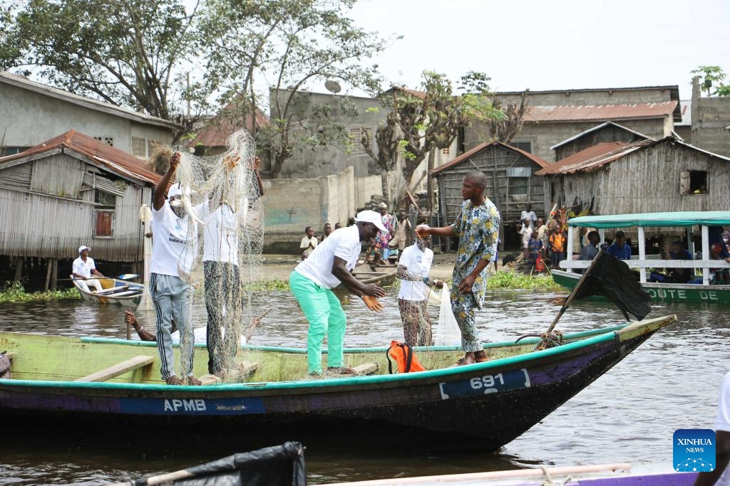 Fishermen work on a canoe on the occasion of World Fisheries Day in So-Ava, a lakeside town near Cotonou, Benin, on Nov. 21, 2023.(Photo: Xinhua)