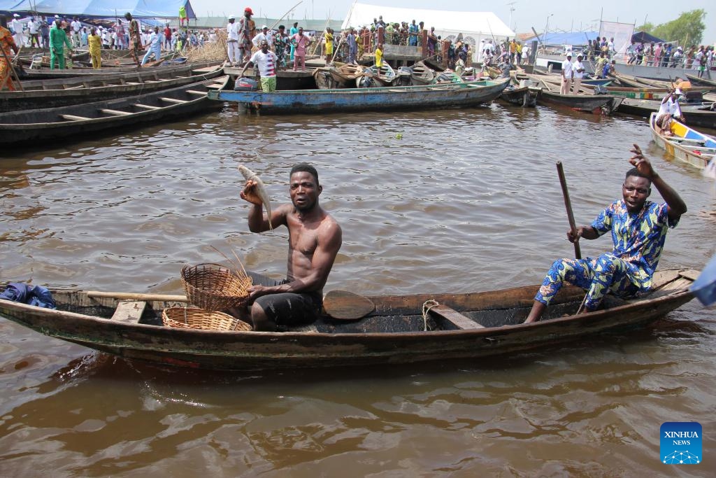 A fisherman shows a fish on the occasion of World Fisheries Day in So-Ava, a lakeside town near Cotonou, Benin, on Nov. 21, 2023(Photo: Xinhua)