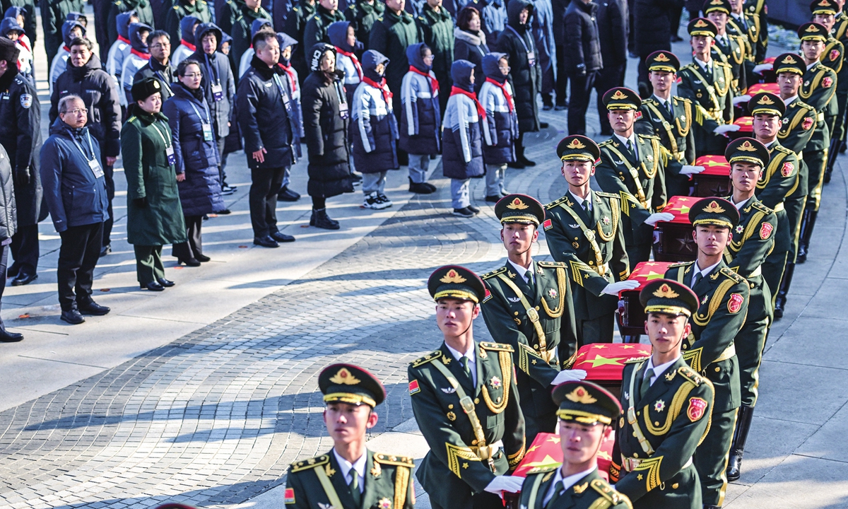 People's Liberation Army soldiers escort the caskets for the remains of 25 Chinese People's Volunteers (CPV) soldiers who sacrificed their lives in the War to Resist US Aggression and Aid Korea (1950-53) during the burial ceremony at the CPV martyrs' cemetery in Shenyang, Northeast China's Liaoning Province, on November 24, 2023. Soldiers, citizens, students and families of the martyrs stood in solemn silence in sub-zero temperatures to see the martyrs off for the last time. Photo: VCG