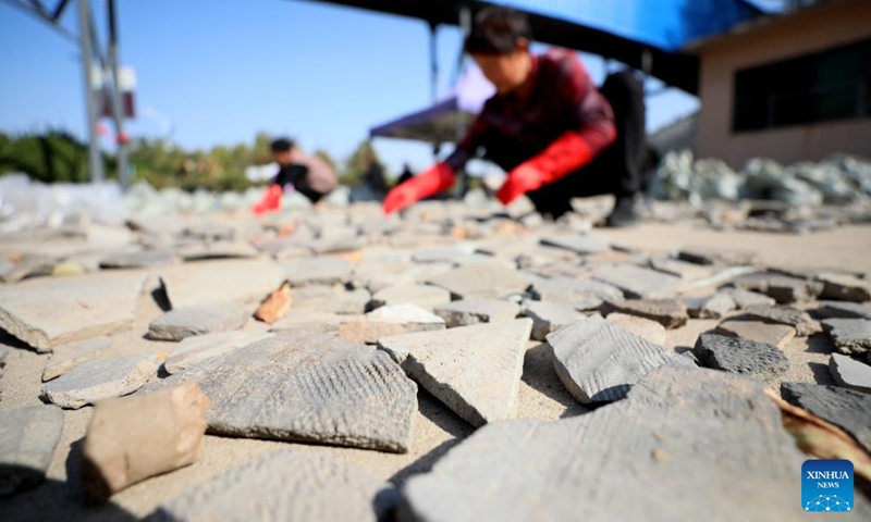 This photo taken on Oct. 25, 2023 shows archaeologists from the Renmin University of China arranging pottery parts unearthed at the Bairen Town site in the city of Xingtai, north China's Hebei Province.(Photo: Xinhua)