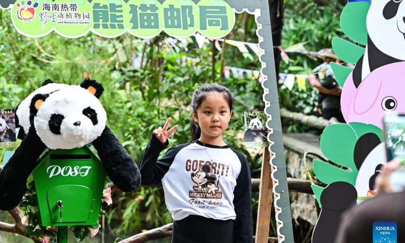 A child poses for photos at the Hainan Tropical Wildlife Park and Botanical Garden in Haikou, south China's Hainan Province, Nov. 25, 2023. Giant pandas Gonggong and Shunshun have lived in Hainan for five years since they made their public debut at the Hainan Tropical Wildlife Park and Botanical Garden in 2018. A celebration ceremony was held here on Saturday, attracting lots of visitors. (Photo: Xinhua)