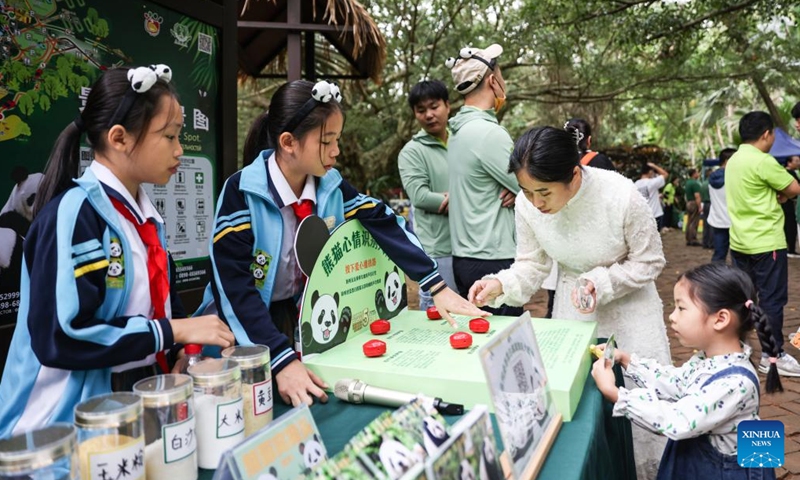 Visitors play an interactive game at the Hainan Tropical Wildlife Park and Botanical Garden in Haikou, south China's Hainan Province, Nov. 25, 2023. Giant pandas Gonggong and Shunshun have lived in Hainan for five years since they made their public debut at the Hainan Tropical Wildlife Park and Botanical Garden in 2018. A celebration ceremony was held here on Saturday, attracting lots of visitors.(Photo: Xinhua)