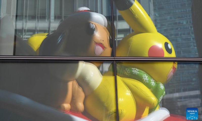 The balloon of Pikachu and Eevee is seen reflected in windows during the 2023 Macy's Thanksgiving Day Parade in New York, the United States, on Nov. 23, 2023.  (Photo: Xinhua)