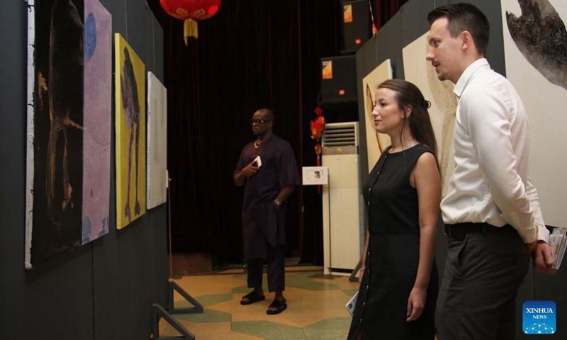 Visitors watch art works exhibited during the exhibition of works of young Chinese and Beninese artists at the Chinese Cultural Center in Cotonou, Benin, Nov. 25, 2023. An exhibition featuring works by 11 Beninese and Chinese artists opened here Saturday evening, aiming to celebrate booming cultural exchanges between the two countries' young artists. (Photo: Xinhua)