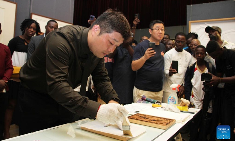 Chinese artist Wang Guanzhou makes works during the exhibition of works of young Chinese and Beninese artists at the Chinese Cultural Center in Cotonou, Benin, Nov. 25, 2023. An exhibition featuring works by 11 Beninese and Chinese artists opened here Saturday evening, aiming to celebrate booming cultural exchanges between the two countries' young artists. (Photo: Xinhua)