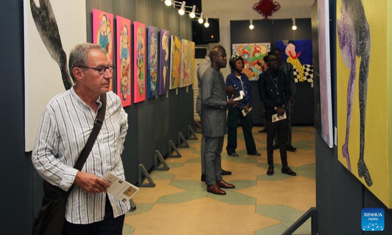 Visitors watch art works exhibited during the exhibition of works of young Chinese and Beninese artists at the Chinese Cultural Center in Cotonou, Benin, Nov. 25, 2023. An exhibition featuring works by 11 Beninese and Chinese artists opened here Saturday evening, aiming to celebrate booming cultural exchanges between the two countries' young artists. (Photo: Xinhua)