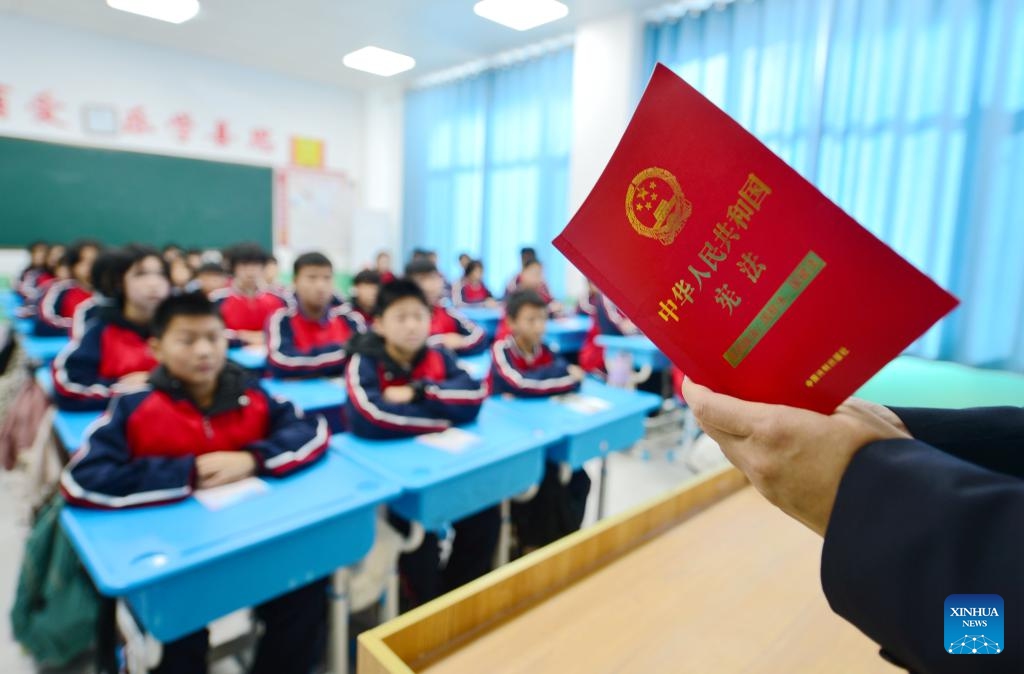 A staff member of local people's procuratorate introduces the Constitution to students at the No. 7 Middle School in Cheng'an County of Handan, north China's Hebei Province, Dec. 4, 2023. China marked its 10th National Constitution Day on Monday.(Photo: Xinhua)