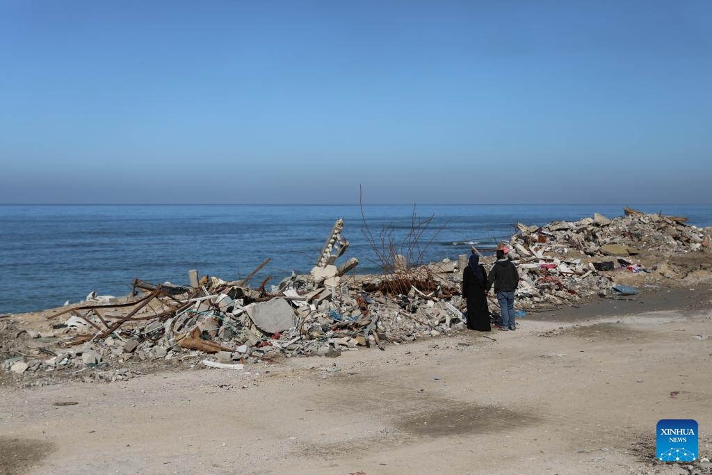 People stand in front of rubble in Gaza City, on Nov. 29, 2023. After weeks of Israeli strikes on Gaza in retaliation for an attack on Oct. 7 by Hamas against Israel, the two sides reached a four-day humanitarian truce last week, which was extended for another two days starting on Tuesday. The Palestinian death toll from the Israel-Hamas conflict has surpassed 15,000, according to Palestinian figures(Photo: Xinhua)