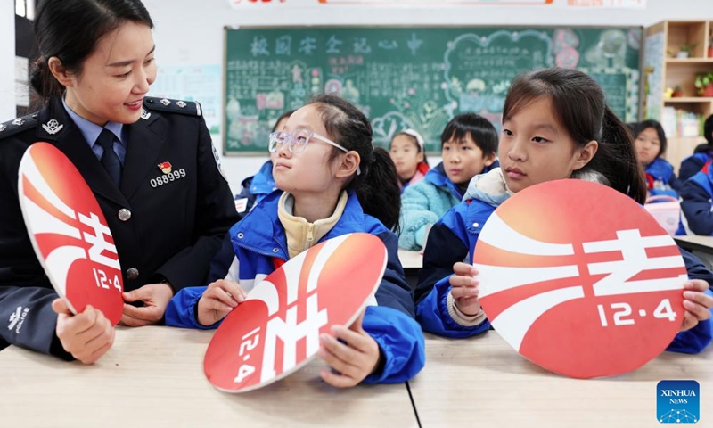 A police officer introduces the Constitution to students at a school in Taizhou, east China's Jiangsu Province, Dec. 4, 2023. China marked its 10th National Constitution Day on Monday(Photo: Xinhua)