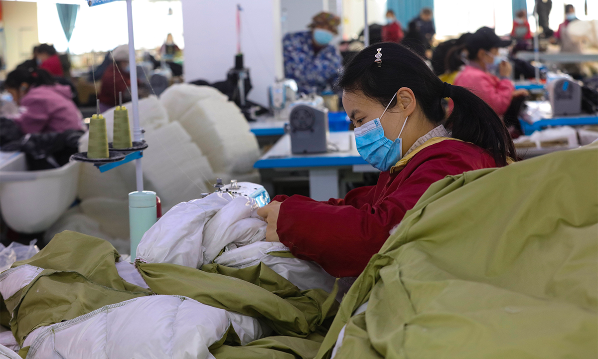 Workers make down jackets as part of a poverty alleviation project in a factory in Xinyang, Central China’s Henan Province on November 30, 2023. Sales of down jackets have been hot in recent days amid a cold wave that has swept across North China. It is estimated that the down jacket market could hit 162.2 billion yuan ($22.74 billion) this year and 195 billion yuan in 2024, maintaining high growth. Photo: VCG