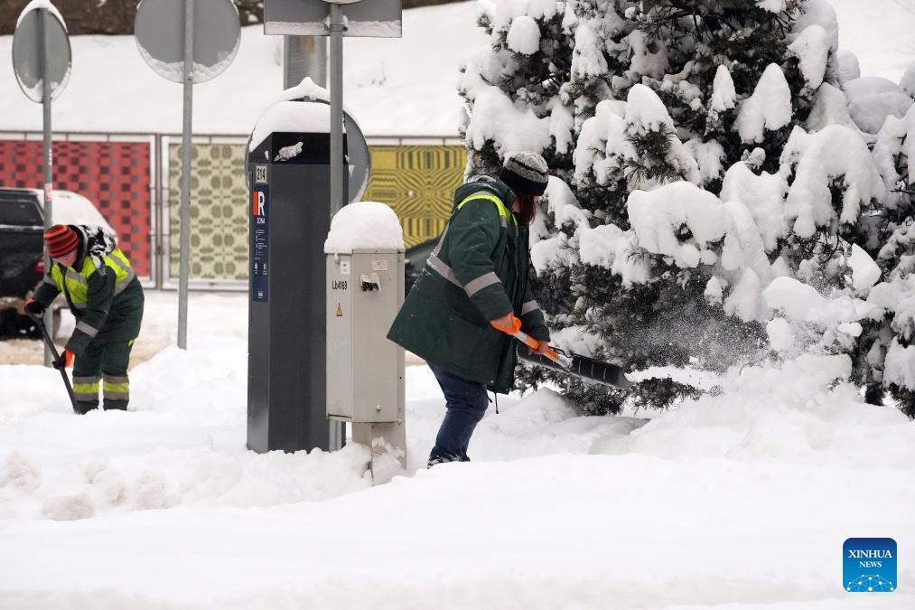 People clear snow in the street in Riga, Latvia, Nov. 30, 2023.(Photo: Xinhua)