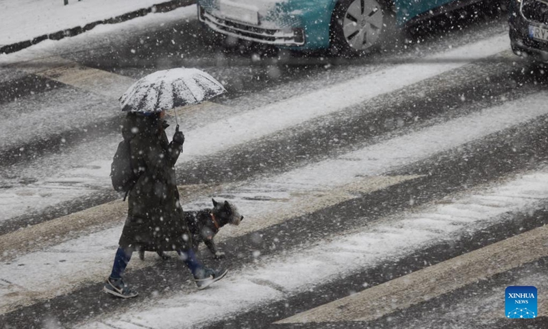 A pedestrian crosses a road in the snow in Budapest, Hungary, on Nov. 30, 2023.(Photo: Xinhua)