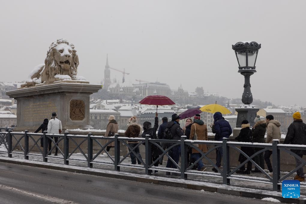 People are seen on the Chain Bridge in the snow in Budapest, Hungary, on Nov. 30, 2023.(Photo: Xinhua)