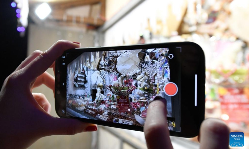 A woman takes a video of sugar-made Christmas-themed figures at the lakeside Christmas market in Montreux, Switzerland, Dec. 2, 2023. The lakeside Christmas market in Montreux is one of the most famous of its kind in the country. (Photo: Xinhua)