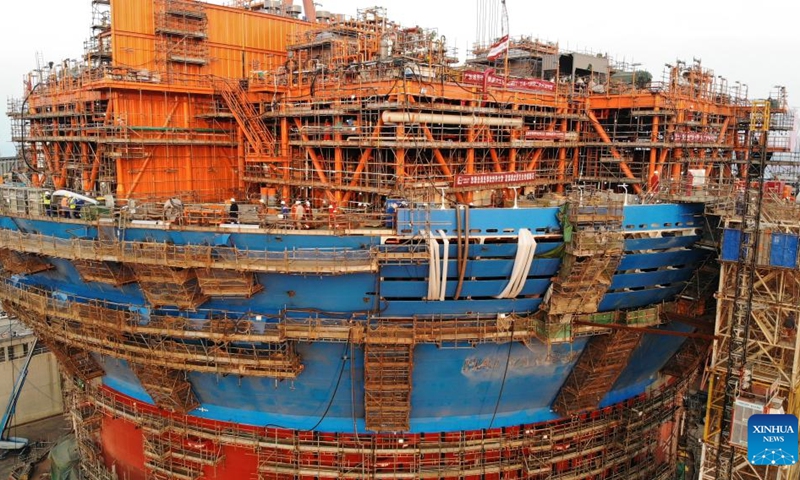 This aerial photo taken on Dec. 4, 2023 shows Haiyang Shiyou 122, Asia's first cylindrical floating, production, storage, and offloading (FPSO) facility, under construction in Qingdao, east China's Shandong Province. Designed and manufactured in China, Haiyang Shiyou 122 has entered its final assembly phase recently in Qingdao. With a diameter of about 90 meters and designed displacement of 100,000 tonnes, the facility is capable of operating for 15 years at sea without returning to the dry dock.(Photo: Xinhua)