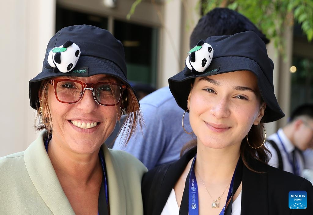 Attendees wearing panda-decorated hats pose for photos at China's pavilion of the 28th session of the Conference of the Parties to the United Nations Framework Convention on Climate Change (COP28), in Dubai, the United Arab Emirates, Dec. 6, 2023. China's pavilion at COP28 was officially inaugurated on Nov. 30 at the Expo City of Dubai.(Photo: Xinhua)