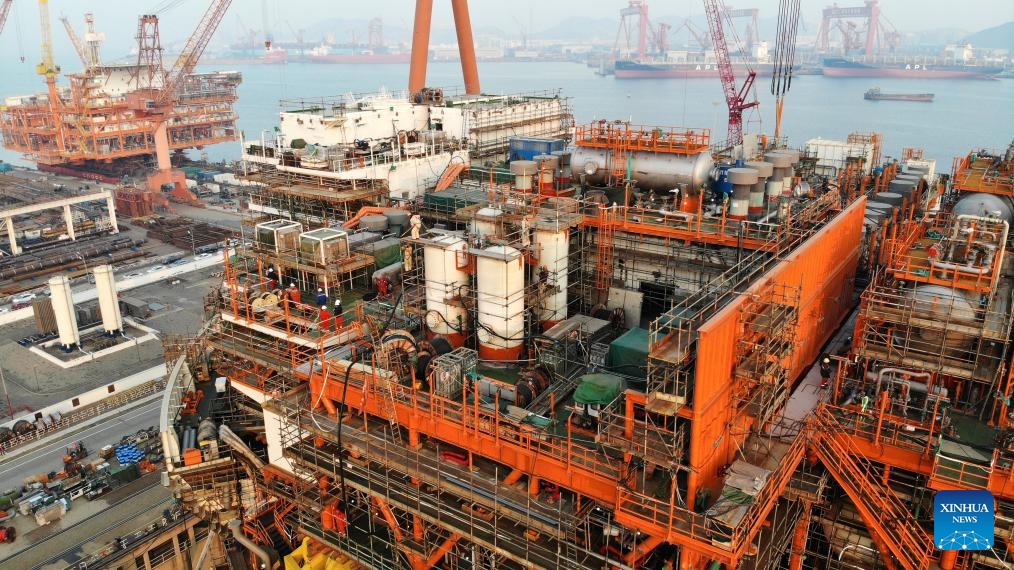 This aerial photo taken on Dec. 4, 2023 shows Haiyang Shiyou 122, Asia's first cylindrical floating, production, storage, and offloading (FPSO) facility, under construction in Qingdao, east China's Shandong Province. Designed and manufactured in China, Haiyang Shiyou 122 has entered its final assembly phase recently in Qingdao. With a diameter of about 90 meters and designed displacement of 100,000 tonnes, the facility is capable of operating for 15 years at sea without returning to the dry dock.(Photo: Xinhua)