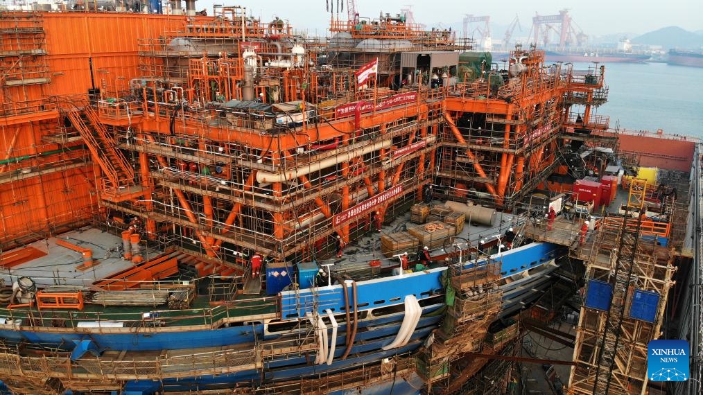 This aerial photo taken on Dec. 4, 2023 shows Haiyang Shiyou 122, Asia's first cylindrical floating, production, storage, and offloading (FPSO) facility, under construction in Qingdao, east China's Shandong Province. Designed and manufactured in China, Haiyang Shiyou 122 has entered its final assembly phase recently in Qingdao. With a diameter of about 90 meters and designed displacement of 100,000 tonnes, the facility is capable of operating for 15 years at sea without returning to the dry dock.(Photo: Xinhua)