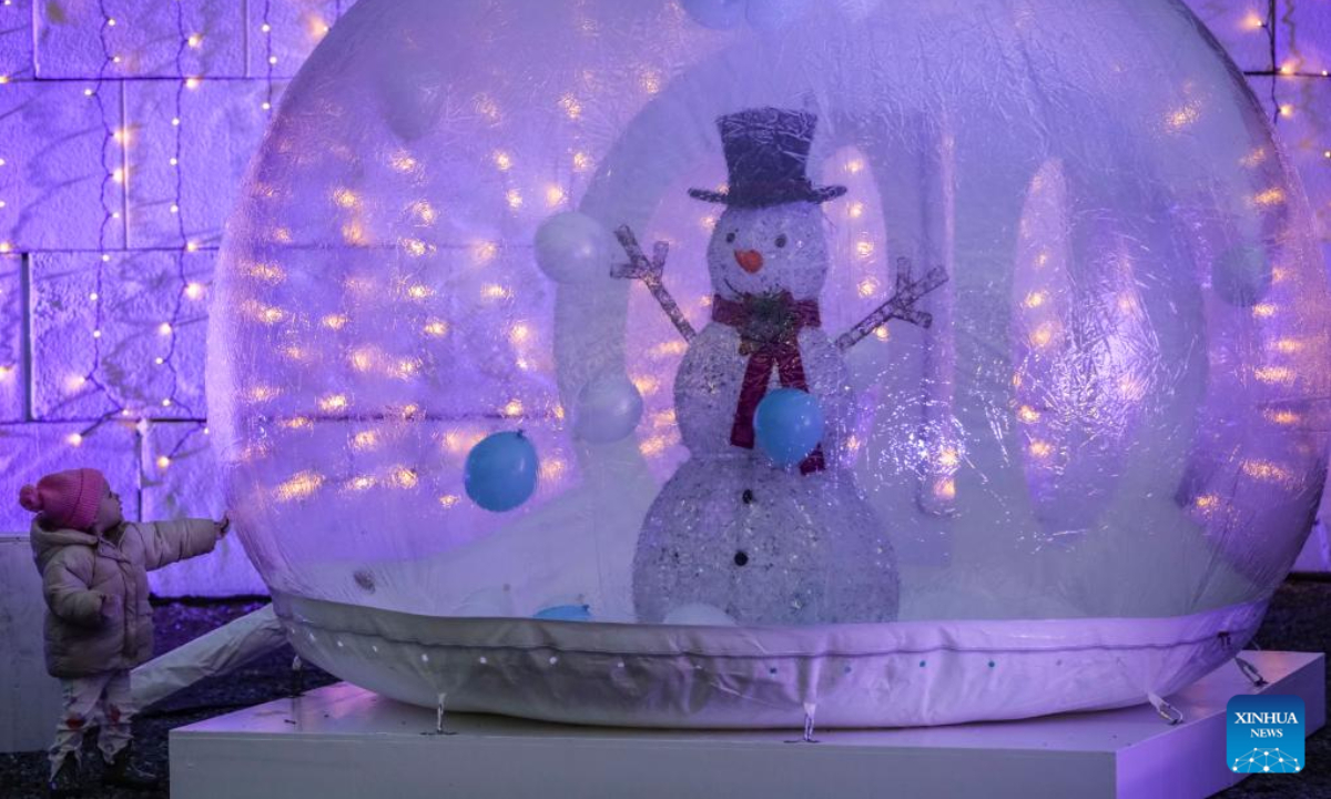 A child is attracted by a snowman installation at the PNE Winter Fair at the Pacific National Exhibition in Vancouver, British Columbia, Canada, Dec. 8, 2023. Photo:Xinhua