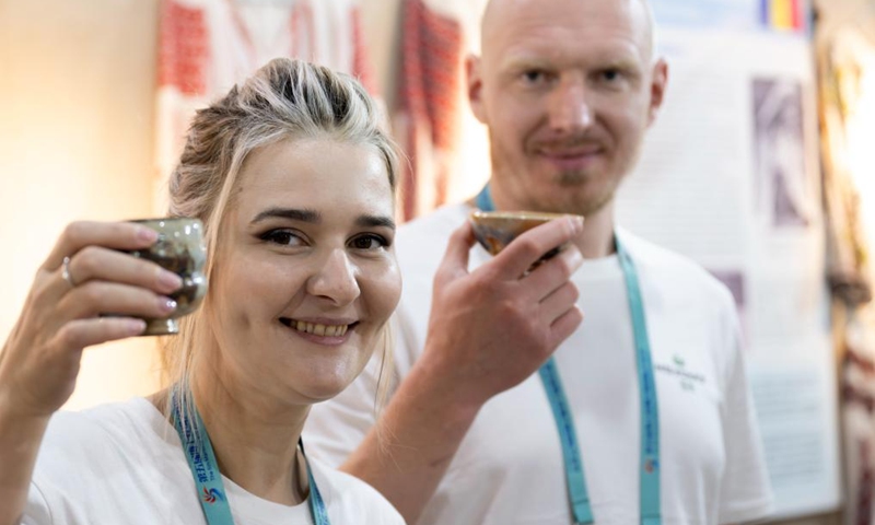 A Russian artist (L) and her cooperator display ceramic cups designed by them during an intangible cultural heritage exhibition on the Maritime Silk Road in Quanzhou, southeast China's Fujian Province, Dec. 9, 2023. The city of Quanzhou is widely believed to be the starting point of the ancient Maritime Silk Road.(Photo: Xinhua)