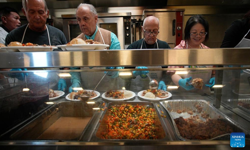 Volunteers dispense food inside a kitchen during the annual Christmas dinner at Union Gospel Mission (UGM) in Vancouver, British Columbia, Canada, on Dec. 9, 2023. (Photo: Xinhua)