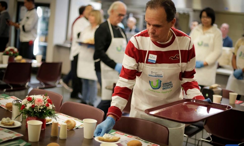 A volunteer distributes desserts during the annual Christmas dinner at Union Gospel Mission (UGM) in Vancouver, British Columbia, Canada, on Dec. 9, 2023. (Photo: Xinhua)