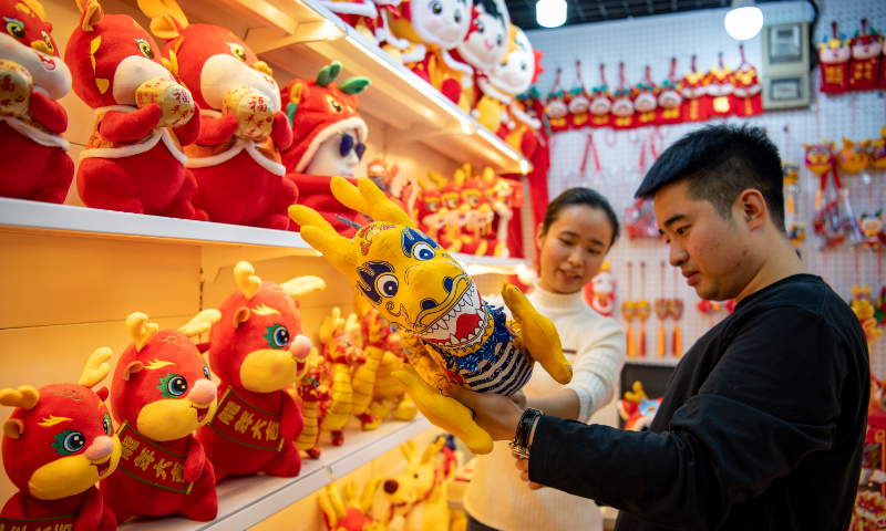 A customer looks at toys with dragon elements at the Yiwu International Trade City in Yiwu, East China's Zhejiang Province, on December 11, 2023. Dragon element crafts are popular with merchants, as 2024 marks the appearance of the dragon in China's 12-year zodiac cycle. Other goods related to the Chinese New Year are also bestsellers. Photo: VCG