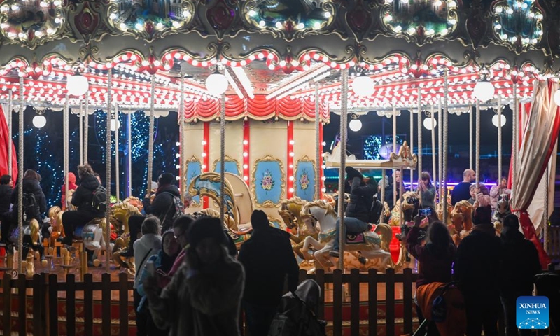 People enjoy a merry-go-round at a Christmas fairyland near the Triton Fountain in Valletta, Malta, Dec. 9, 2023. The fairyland decorated with Christmas lights was opened on Dec. 8, 2023 and will stay open until Jan. 7, 2024. (Photo: Xinhua)