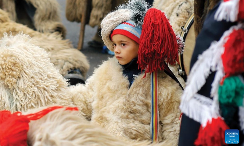 A child of a traditional song and dance band attends the White Flowers festival of traditions and customs at the Village Museum in Bucharest, capital of Romania, on Dec. 10, 2023. The festival is organized annually with the aim of presenting Christmas and New Year traditions to the public. (Photo: Xinhua)
