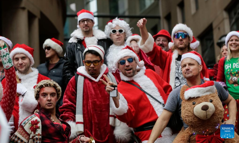 People dressed as Santa Claus participate in the annual SantaCon event in Vancouver, British Columbia, Canada, on Dec. 16, 2023. (Photo by Liang Sen/Xinhua)