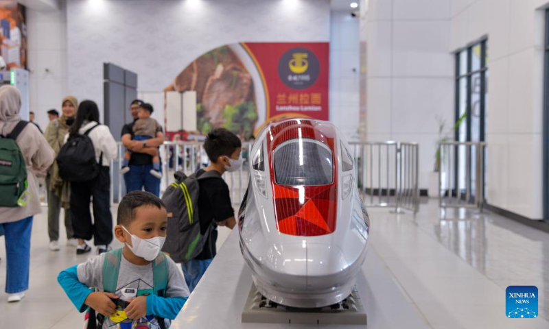 Two boys look at a model of a high-speed electrical multiple unit (EMU) train of the Jakarta-Bandung high-speed railway at Halim Station in Jakarta, Indonesia, Dec. 17, 2023. According to PT Kereta Cepat Indonesia-China (KCIC), a joint venture consortium between Indonesian and Chinese state-owned firms that constructs and runs the Jakarta-Bandung high-speed railway (HSR), the HSR has delivered more than 700,000 passengers since it was officially put into commercial operation on Oct. 17. (Xinhua/Xu Qin)