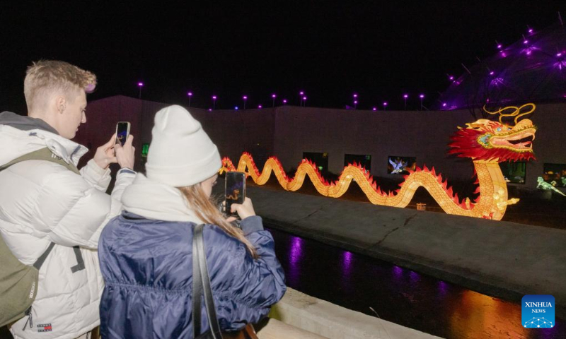 Visitors take photos at the Year of the Dragon Lantern Festival in Budapest Zoo in Budapest, Hungary, Dec. 16, 2023. (Photo by Attila Volgyi/Xinhua)