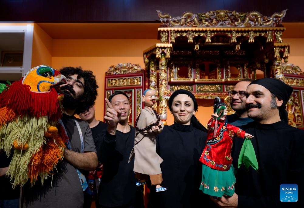 Chen Daigong (4th R), puppeteer and inheritor of a local Chinese puppet performing art, talks with Iranian puppeteers at a puppet art preservation center in Jinjiang of Quanzhou City, southeast China's Fujian Province, Dec. 11, 2023. Puppet artists from 12 countries are invited to Quanzhou, a city widely believed to be the starting point of the ancient Maritime Silk Road, to give puppet performances and communicate with local puppet artists.(Photo: Xinhua)