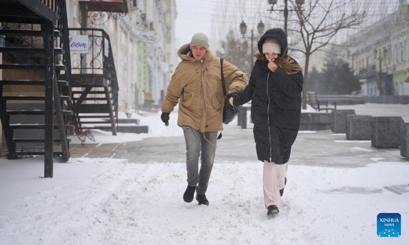 People walk against the blizzard in Vladivostok, Russia, Dec. 16, 2023. (Photo by Guo Feizhou/Xinhua)