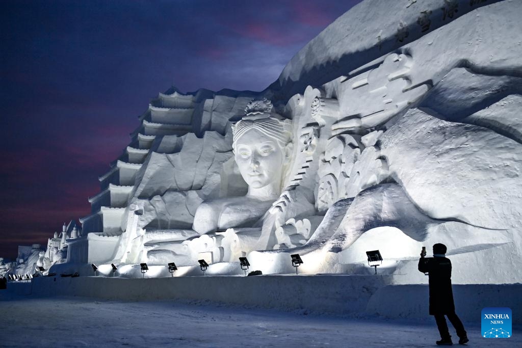 A tourist takes photos of a giant snow sculpture at Changchun Ice and Snow New World in Changchun, northeast China's Jilin Province, Dec. 12, 2023. The 27th Changchun Ice and Snow Festival kicked off here on Tuesday.(Photo: Xinhua)