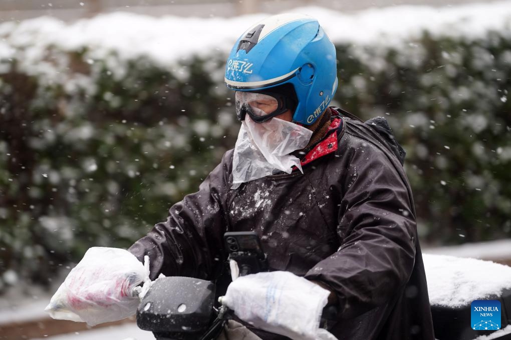 A deliveryman rides in the snow on Yangfangdian Road in Beijing, capital of China, Dec. 13, 2023.(Photo: Xinhua)