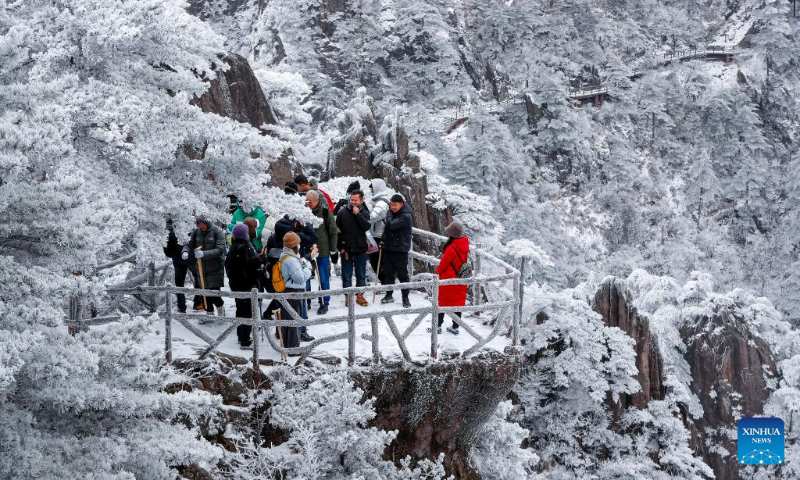 Tourists enjoy the snow scenery at the Huangshan Mountain scenic area in Huangshan City, east China's Anhui Province, Dec. 16, 2023. The scenic area witnessed the first snowfall in this winter recently. (Photo by Shi Yalei/Xinhua)