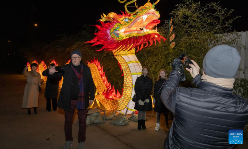 People take photos at the Year of the Dragon Lantern Festival in Budapest Zoo in Budapest, Hungary, Dec. 16, 2023. (Photo by Attila Volgyi/Xinhua)