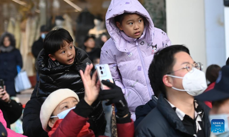 People watch as a mechanical device Horse Dragon Long Ma parades on a street in Gongshu District of Hangzhou, east China's Zhejiang Province, Dec. 16, 2023. (Xinhua/Huang Zongzhi)