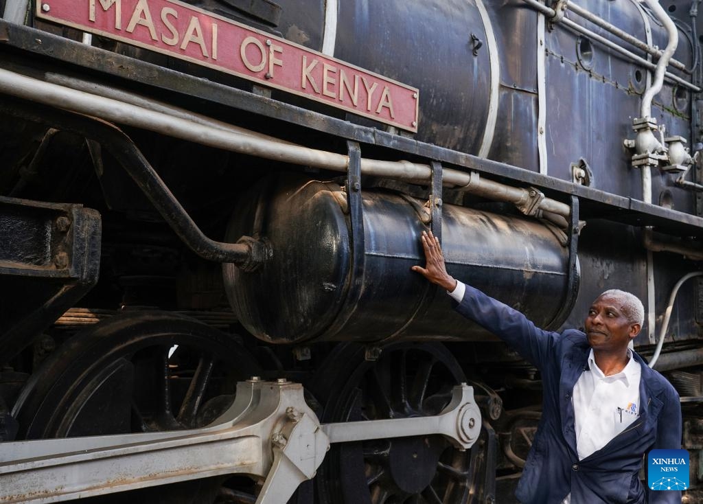 Sevily Mwailemi, a locomotive driver with over three decades of experience, touches a locomotive prototype at the Nairobi Railway Museum in Nairobi, Kenya, on Nov. 27, 2023. The Nairobi Railway Museum, nestled in Nairobi's bustling downtown, remains a popular destination for both locals and tourists eager to delve into Kenya's rich history.(Photo: Xinhua)