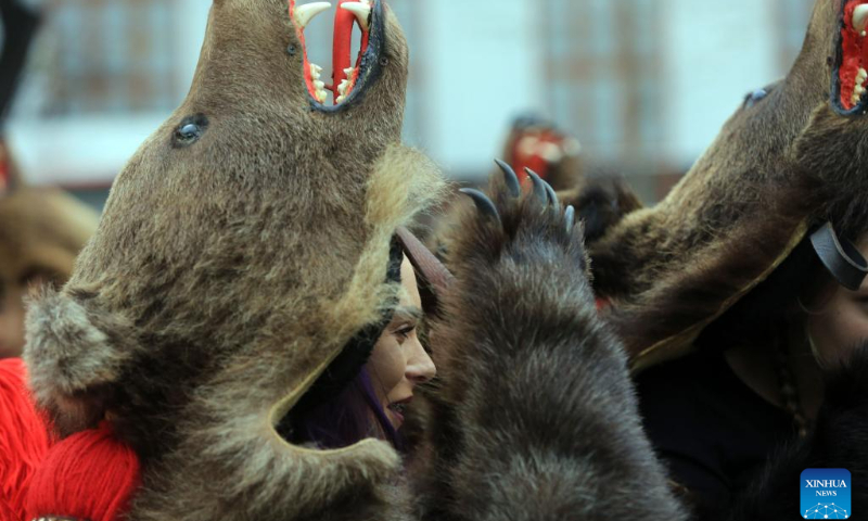 A member of a traditional song and dance band performs bear dance during the 